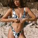 Woman in a black and white patterned bikini, brazilian bikini bottoms and clip front top