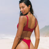 Girl wearing cherry red brazilian bikini bottoms, from the back