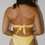 Sophia wearing a yellow bikini against a plain background