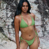 Sophie, Triangle Bikini Top -  Matcha worn by model on a beach, showcasing adjustable halter tie straps and removable cup padding.